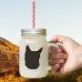 Schwarze Kroatienische Schäferhund-Silhouette in einem frostigen Glas-Mason-Jar mit Strohhalme.
